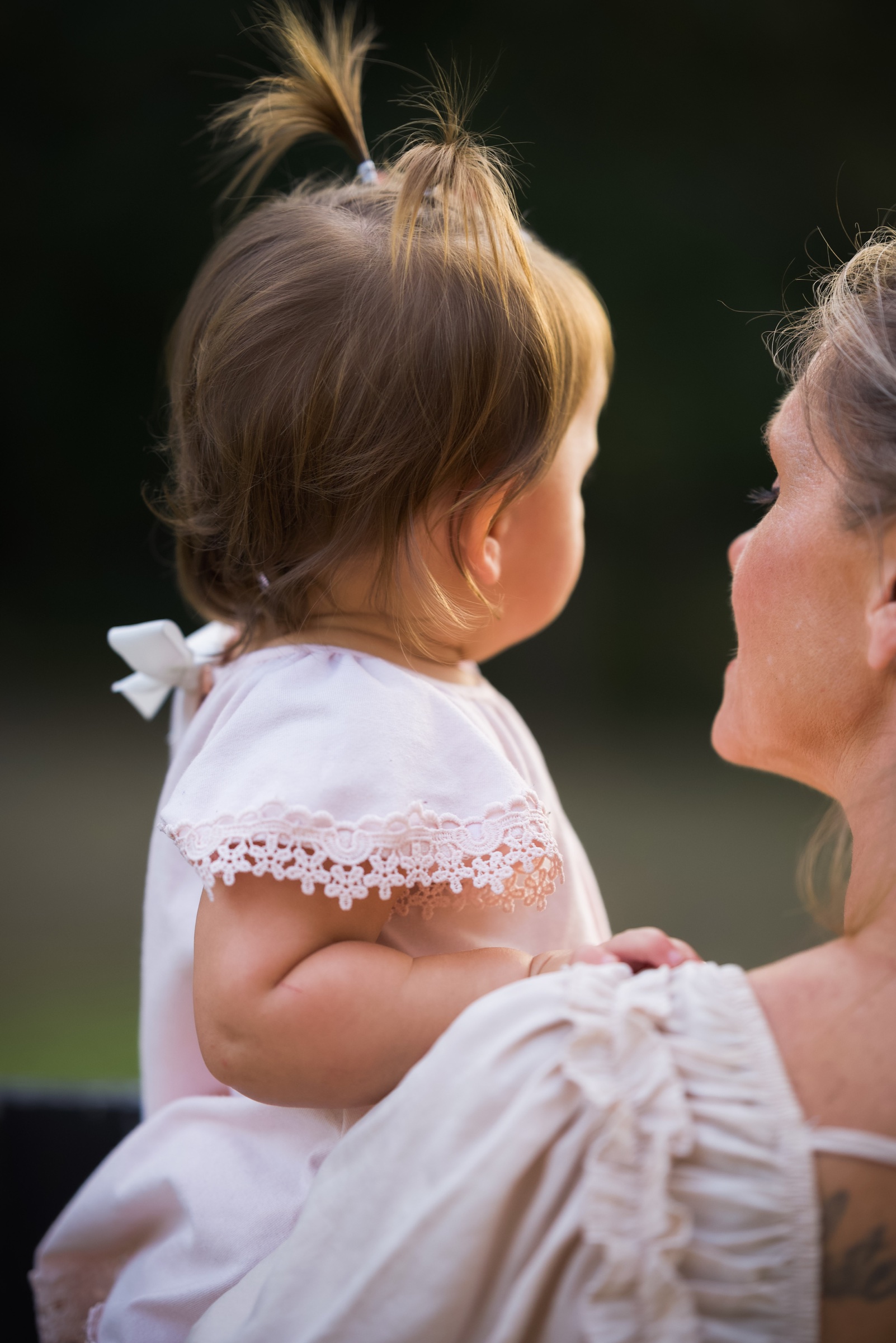 Mother holding her young daughter close in warm evening light