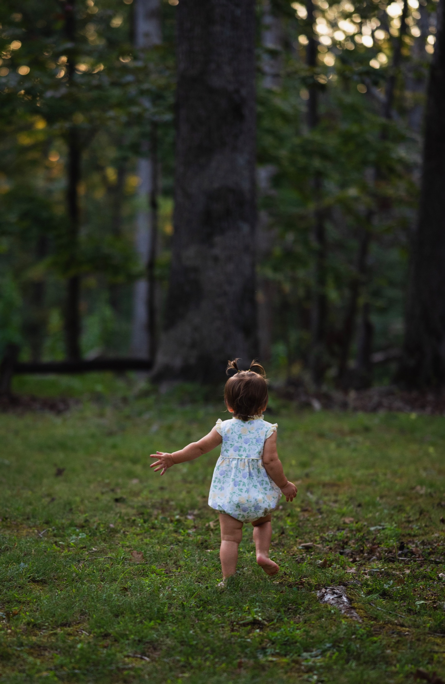Young child walking barefoot through a wooded clearing
